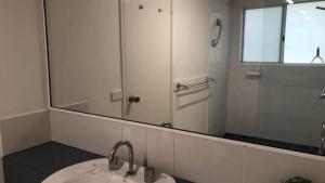 a bathroom with a sink and a mirror at Spinnaker Seas Unit 2 in Caloundra +3 photos