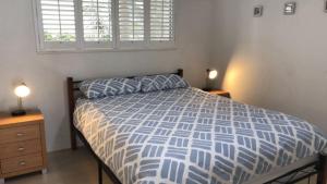 a bedroom with a bed and two night stands and a window at Spinnaker Seas Unit 2 in Caloundra