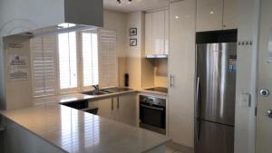 a large kitchen with a stainless steel refrigerator at Spinnaker Seas Unit 2 in Caloundra