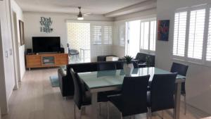 a dining room and living room with a table and chairs at Spinnaker Seas Unit 2 in Caloundra