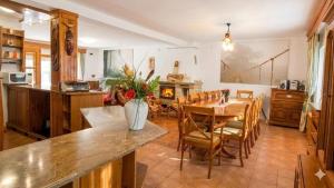 a kitchen and dining room with a table and chairs at Cabana de la rau Satic in Sătic