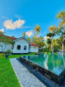 a swimming pool in front of a house at Casa Del Ceylon in Hikkaduwa