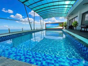a swimming pool with a view of the ocean at Khách Sạn Moonlight FLC Sầm Sơn in Sầm Sơn