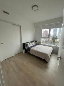 a bedroom with a bed and a large window at Cozy private bedroom and bathroom in Surrey