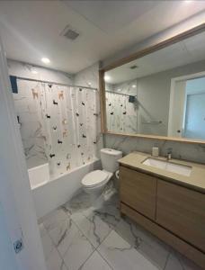 a bathroom with a toilet and a sink and a mirror at Cozy private bedroom and bathroom in Surrey