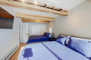 a bedroom with two beds with blue pillows at Vail International 204 in Vail +40 photos