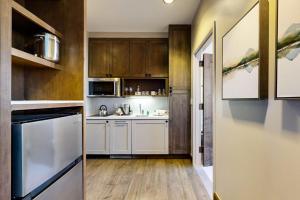 a kitchen with white appliances and wooden cabinets at Riverfront Escape #320 in Avon