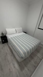 a large bed in a white room with a wooden floor at Olympicpark 12 Free Parking in Sydney
