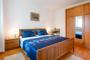 a bedroom with a large bed with blue sheets at Apartment Gorgo in Sečovlje