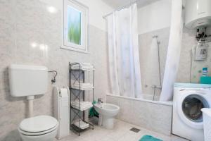a bathroom with a toilet and a washing machine at Apartment Gorgo in Sečovlje +10 photos