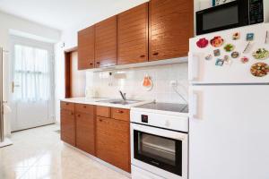 a kitchen with a white refrigerator and wooden cabinets at Apartment Gorgo in Sečovlje