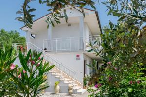 a white building with stairs and plants at Apartment Gorgo in Sečovlje