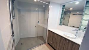 a bathroom with a glass shower and a sink at Grand Pacific Unit 10 in Caloundra +5 photos