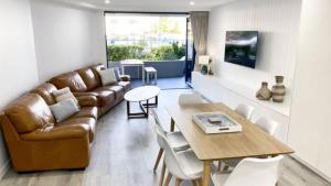 a living room with a couch and a table at Grand Pacific Unit 10 in Caloundra