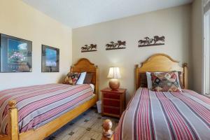 a bedroom with two beds and a table with a lamp at Sun Vail 24B in Vail +56 photos