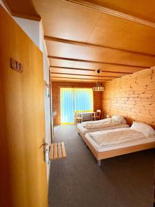a bedroom with two beds in a wooden wall at Hotel Gebidem in Visperterminen