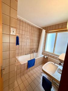 a bathroom with a tub and a sink and a bath tub at Hotel Gebidem in Visperterminen