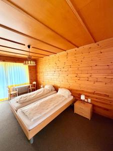 a bedroom with two beds in a wooden wall at Hotel Gebidem in Visperterminen +24 photos
