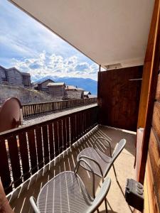 a balcony with two chairs and tables and a view at Hotel Gebidem in Visperterminen