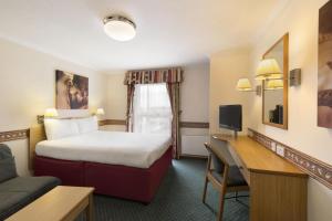 a hotel room with a bed and a desk at Days Inn Hotel Leicester in Leicester