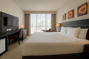 a hotel room with a bed and a desk and a television at Tryp by Wyndham Panama Centro in Panama City +54 photos