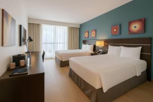 a hotel room with two beds and a desk at Tryp by Wyndham Panama Centro in Panama City