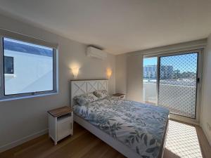 a bedroom with a bed and a large window at Pumicestone Chase Unit 8 in Caloundra +8 photos