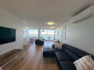 a living room with a couch and a tv at Pumicestone Chase Unit 8 in Caloundra
