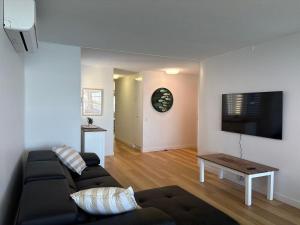 a living room with a couch and a flat screen tv at Pumicestone Chase Unit 8 in Caloundra