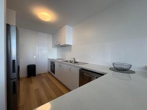 a white kitchen with a sink and a counter top at Pumicestone Chase Unit 8 in Caloundra