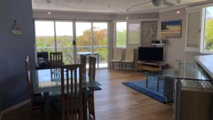 a dining room and living room with a table and chairs at Outlook Unit 7 in Kawana Waters +7 photos