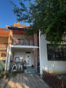 a house with a patio with a table and a balcony at Arnold Apartmanház in Bük