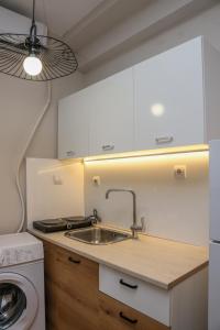 a kitchen with a sink and a washing machine at Cozy Twins - Petra in Kavála