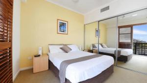 a bedroom with a large bed and a balcony at Rolling Surf Resort Unit 48 in Caloundra +6 photos