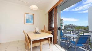 a dining room with a table and chairs on a balcony at Rolling Surf Resort Unit 48 in Caloundra
