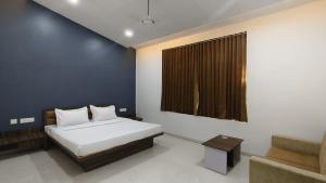 a bedroom with a bed and a window and a couch at Nal Village Resort By Explore With Nirav in Rupāwati