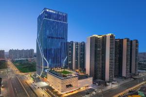 a tall glass building in a city with buildings at Wyndham Shanwei Haifeng in Shanwei