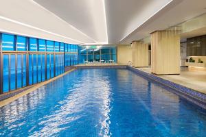 a swimming pool with blue water in a building at Wyndham Shanwei Haifeng in Shanwei