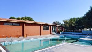 a swimming pool in front of a building at Nal Village Resort By Explore With Nirav in Rupāwati +35 photos