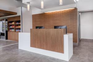 a lobby with a reception desk with two chairs at Wingate by Wyndham Geneva at SPIRE Academy in Geneva