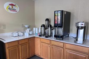 a kitchen counter with a coffee maker on top of it at Super 8 by Wyndham Lumberton NC in Lumberton