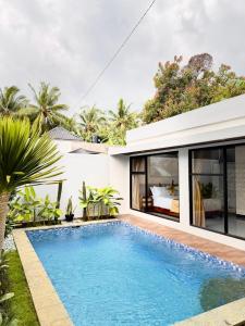 an image of a swimming pool in front of a villa at Griya Becik Lovina - Private Pool Villa near Lovina Dolphin Spot in Lovina