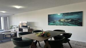 a dining room with a table and a turtle on the wall at Seabourn Unit 502 in Caloundra