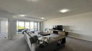 a living room with a couch and a tv at Seabourn Unit 502 in Caloundra