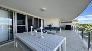 a living room with a table and a couch on a balcony at Seabourn Unit 502 in Caloundra