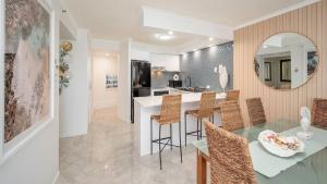 a kitchen and dining room with a table and chairs at Grand Pacific Unit 104 in Caloundra
