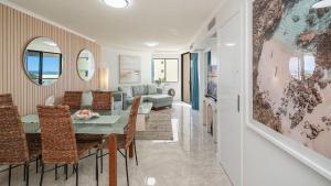 a dining room and living room with a table and chairs at Grand Pacific Unit 104 in Caloundra