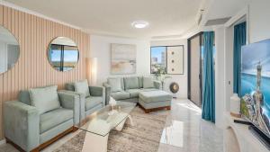 a living room with two couches and a tv at Grand Pacific Unit 104 in Caloundra