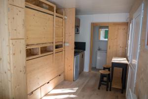 a room with wooden walls and a kitchen with a counter at La Permaculturelle - Domaine des Ramières in Le Poët-Laval
