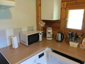 a kitchen with a microwave on a wooden counter top at Cottage-karaoke Koivikko in Äänekoski